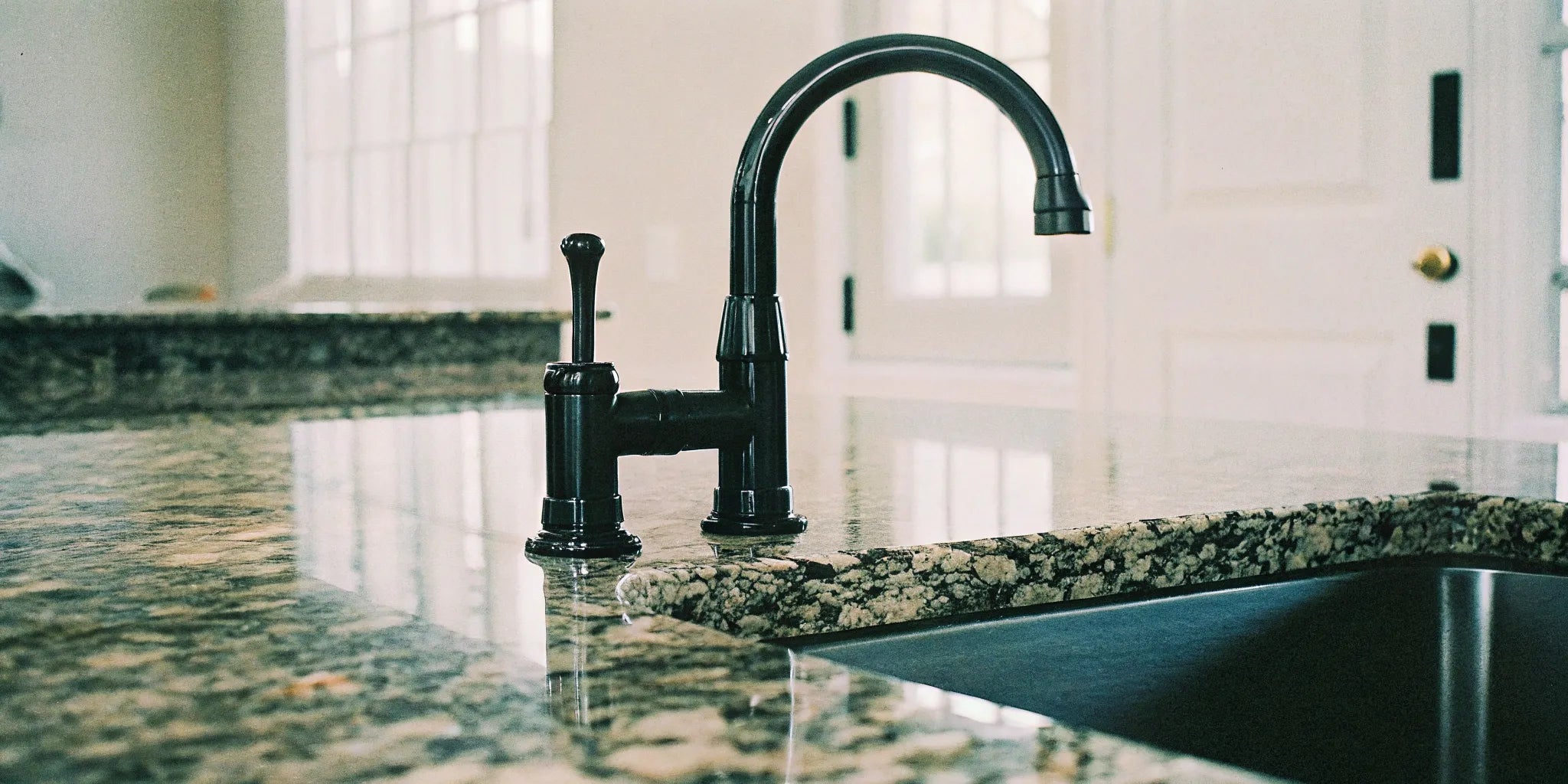 Sleek black modern kitchen faucet in a newly upgraded kitchen.