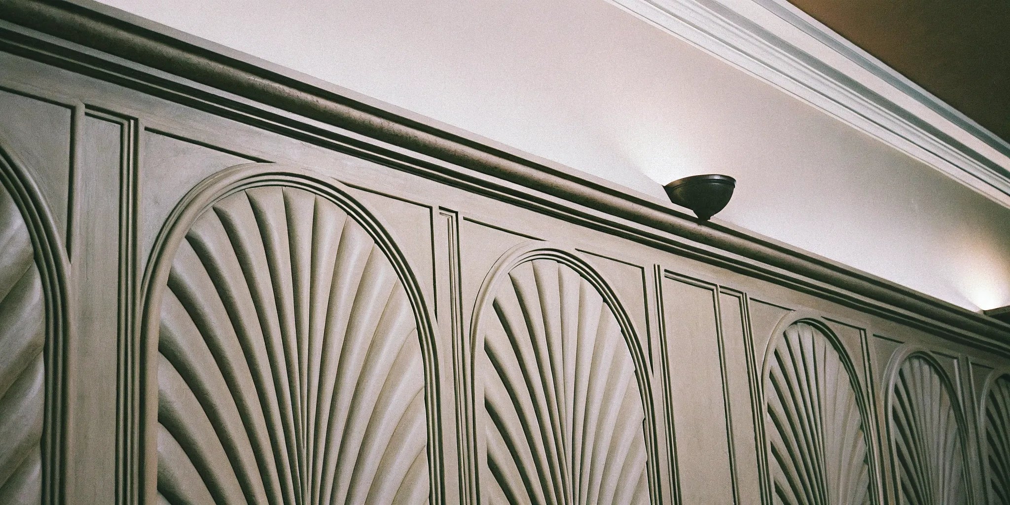 Arched decorative fluted wall panels creating an elegant feature wall in a modern interior.
