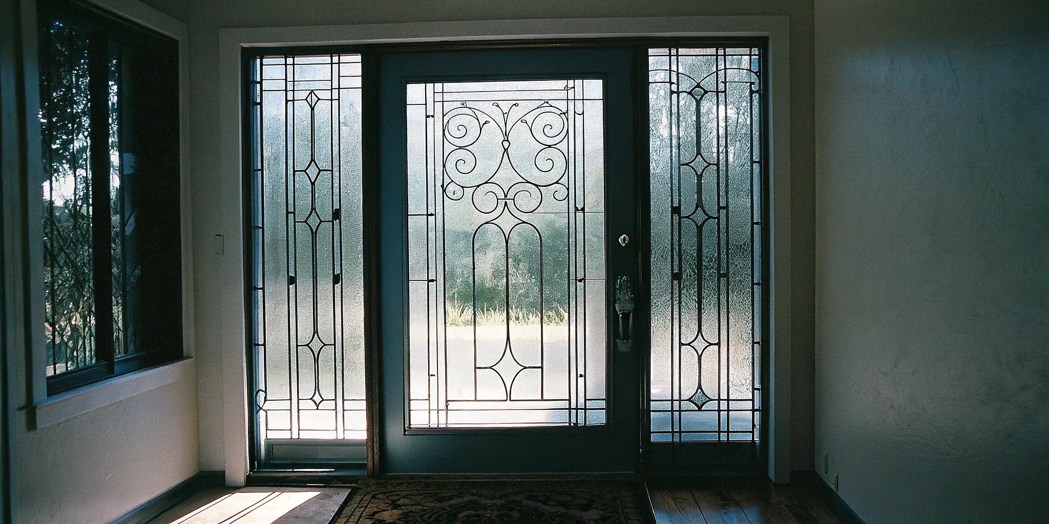 Secure steel entry door with decorative glass sidelights, boosting curb appeal and natural light.