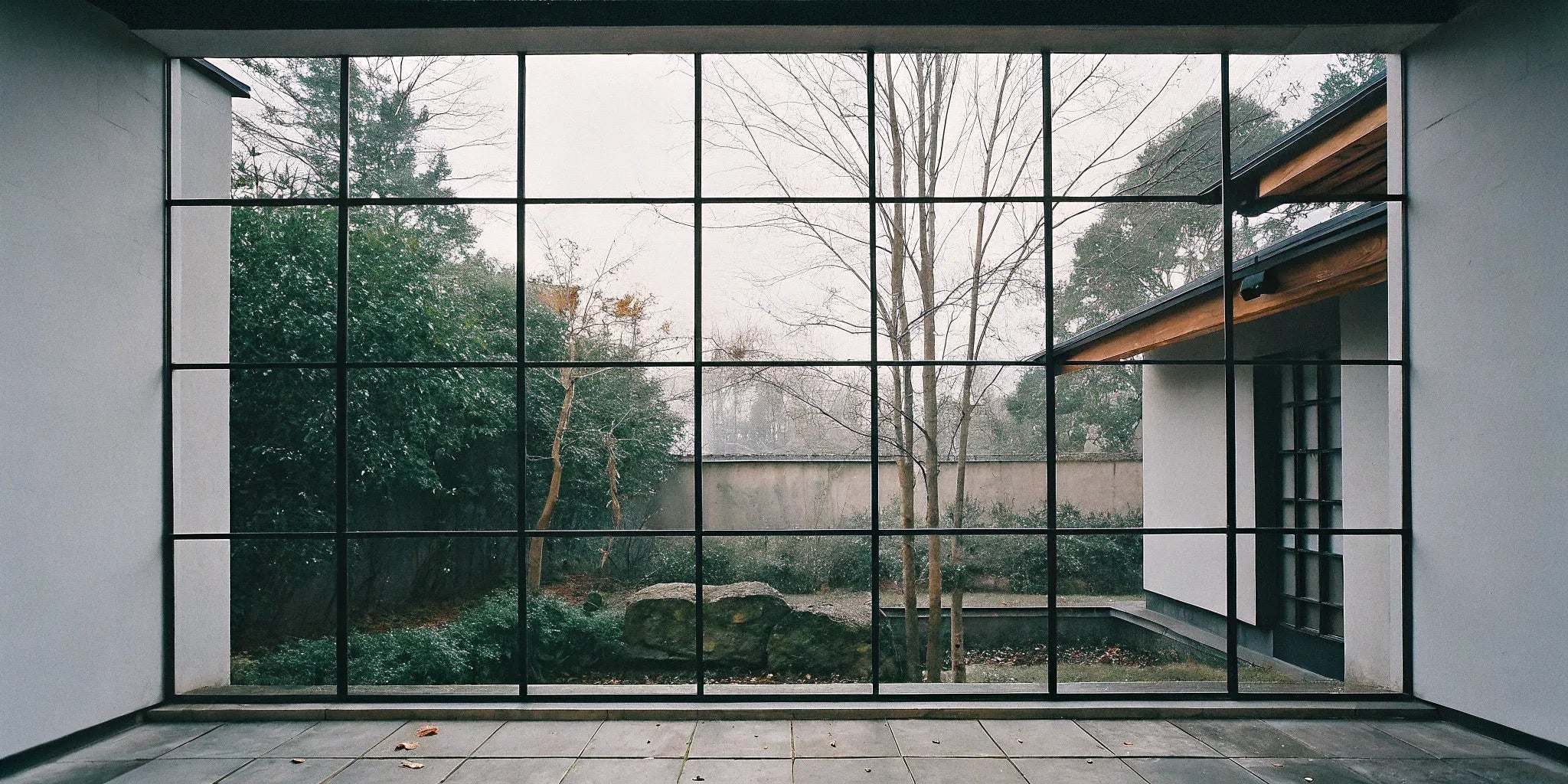 Residential black steel frame windows in a modern living space with a garden view.