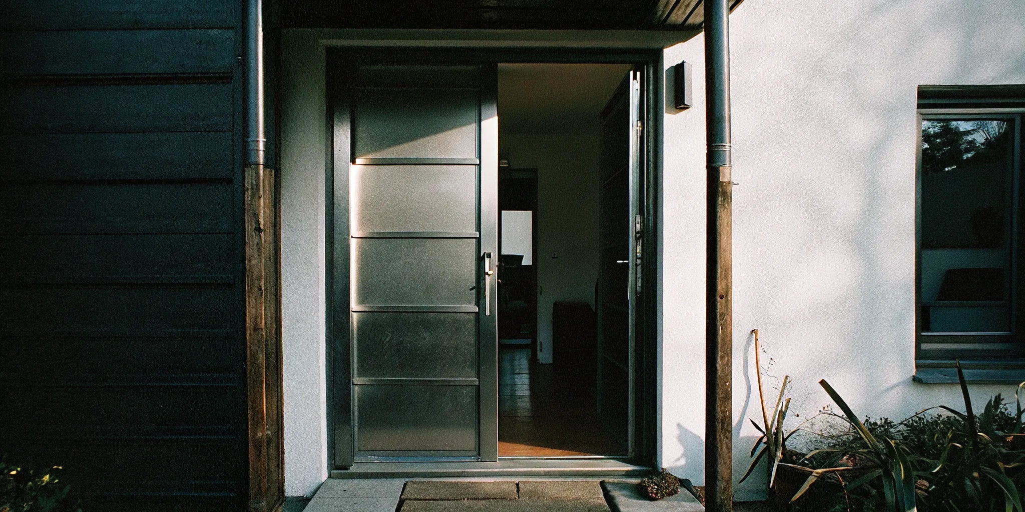 Energy-efficient 36x80 steel front door with frame, installed in a bright, modern entryway.