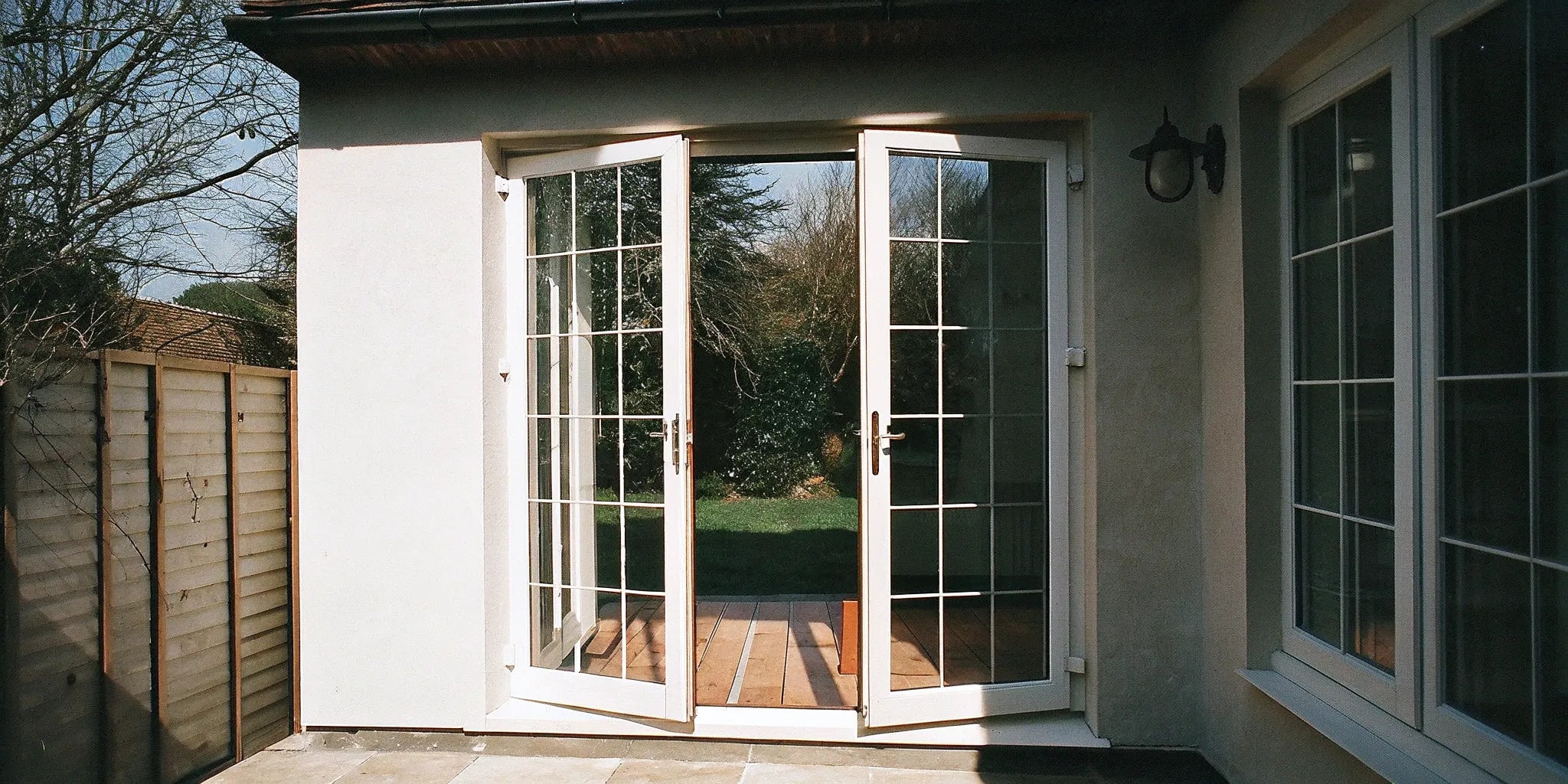 Black exterior steel French doors with large glass panels opening onto a home patio.