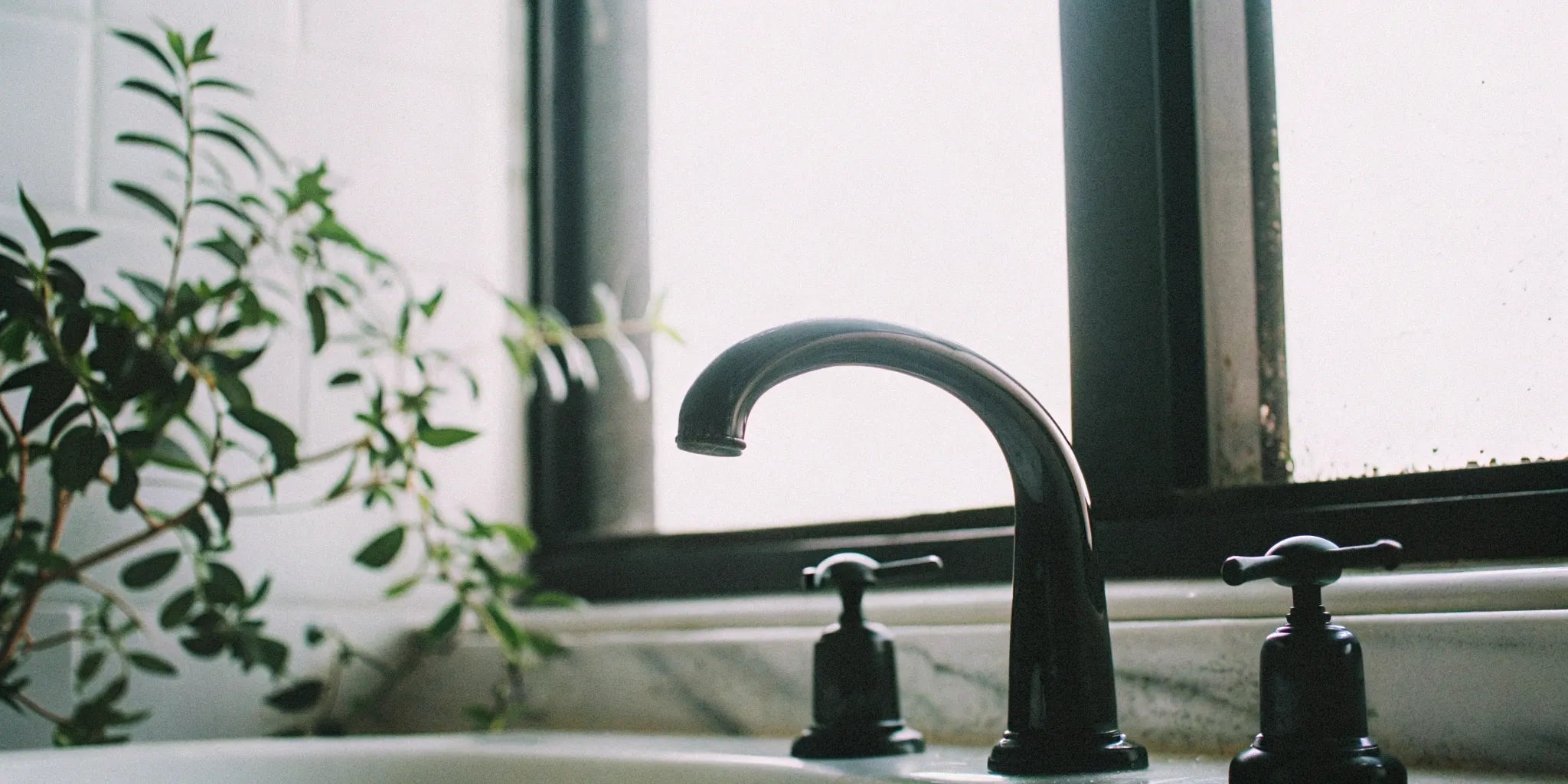 A clean matte black bathroom faucet after being wiped down to prevent damage.
