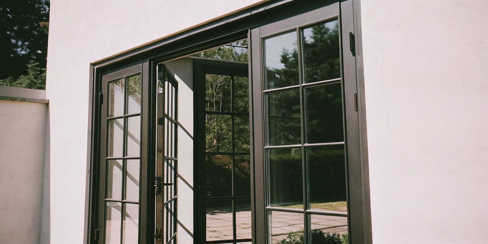 Modern black exterior French doors with large glass panels and minimalist frames.