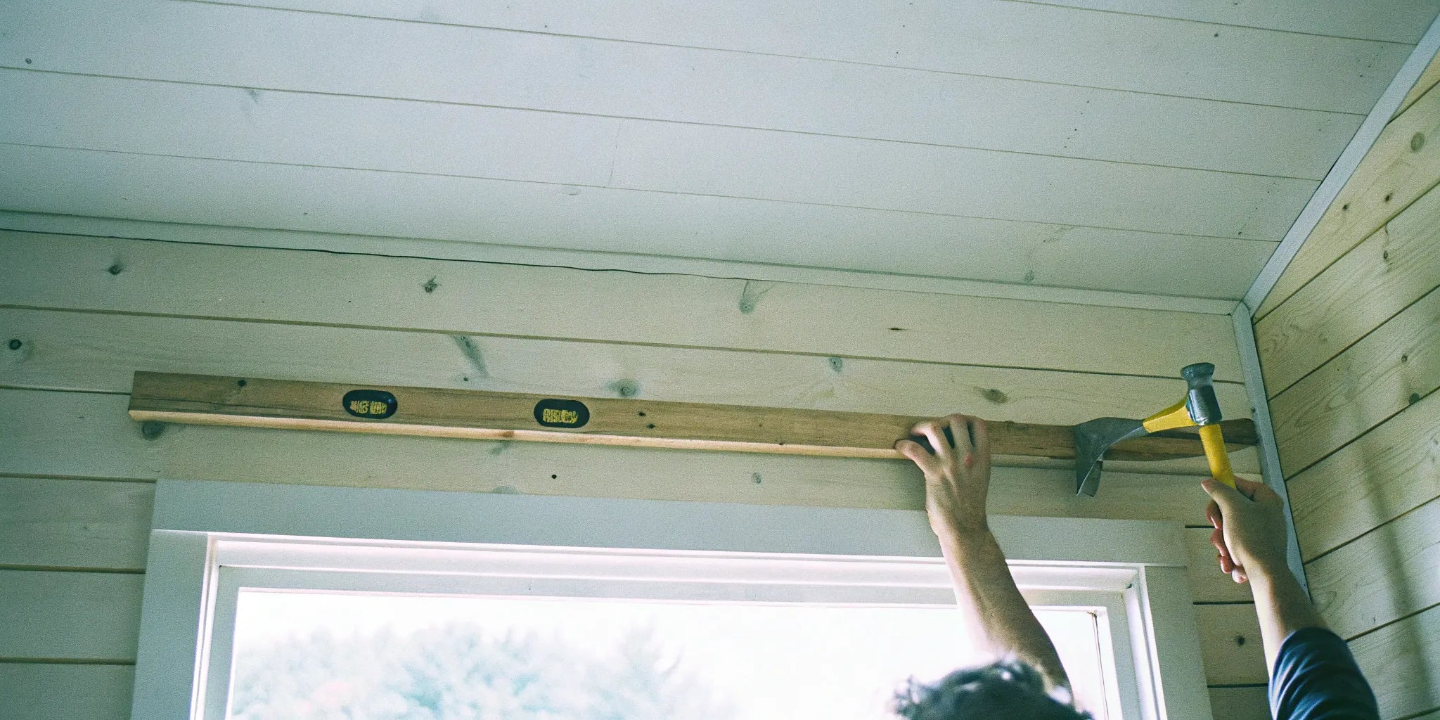 Shiplap wall panel installation using level.