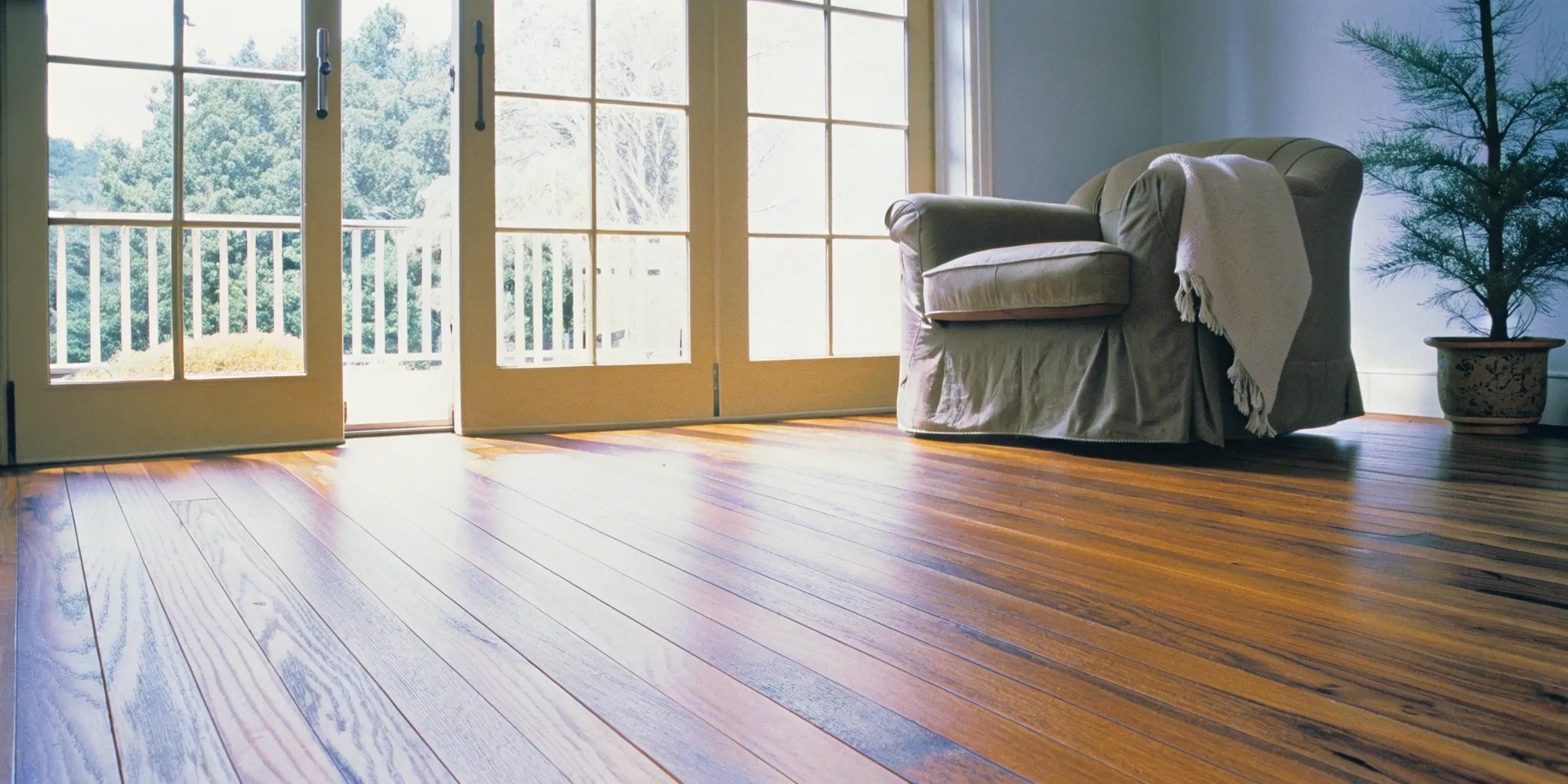 Engineered wood flooring in a sunlit living room with modern decor.