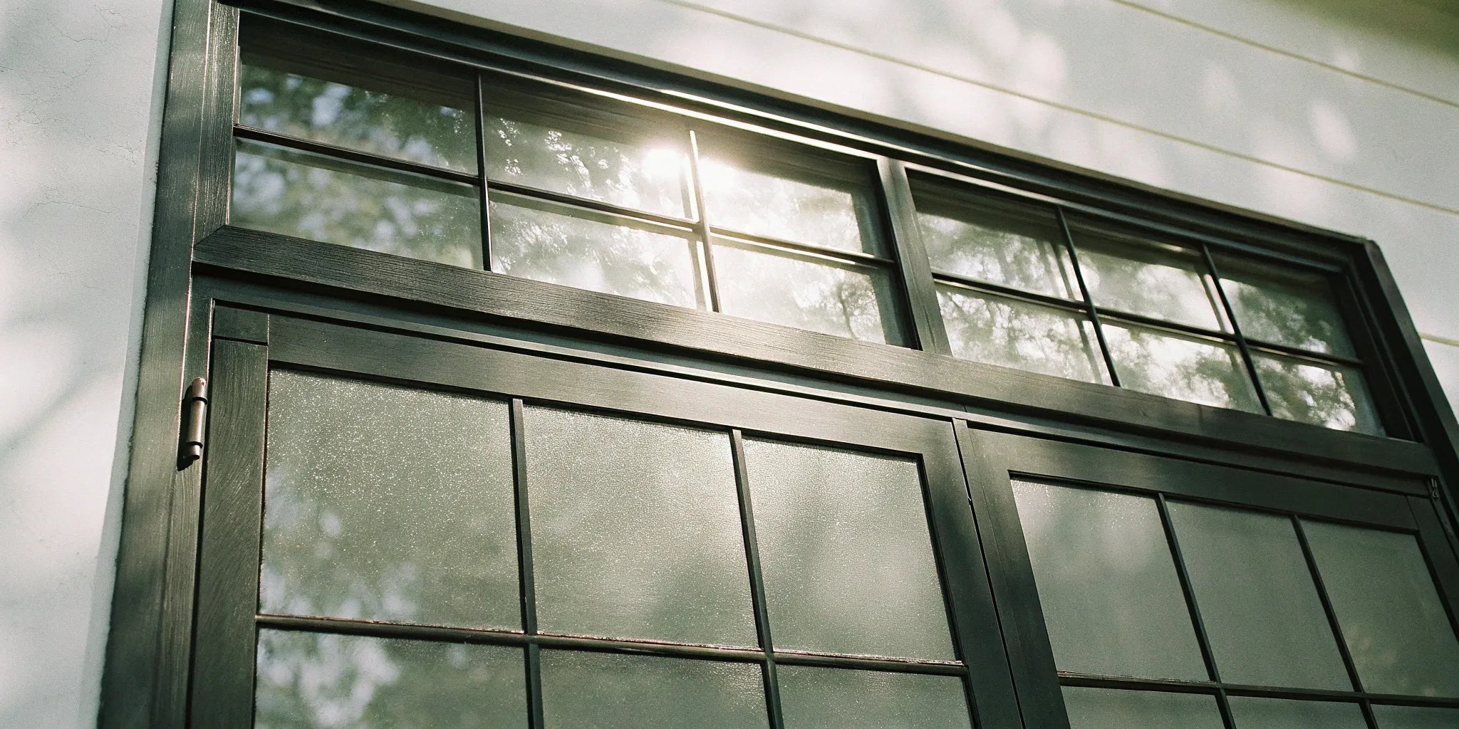 The cost of black steel windows on a modern home with a divided-pane design.