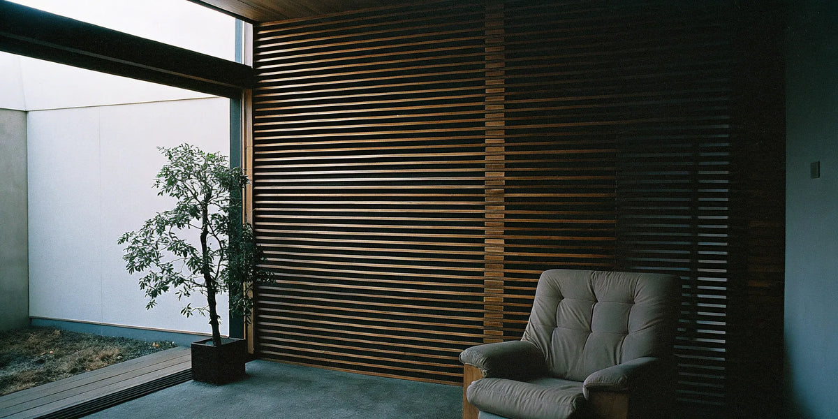 A horizontal wood slat wall as an accent in a modern living room with an armchair and plant.