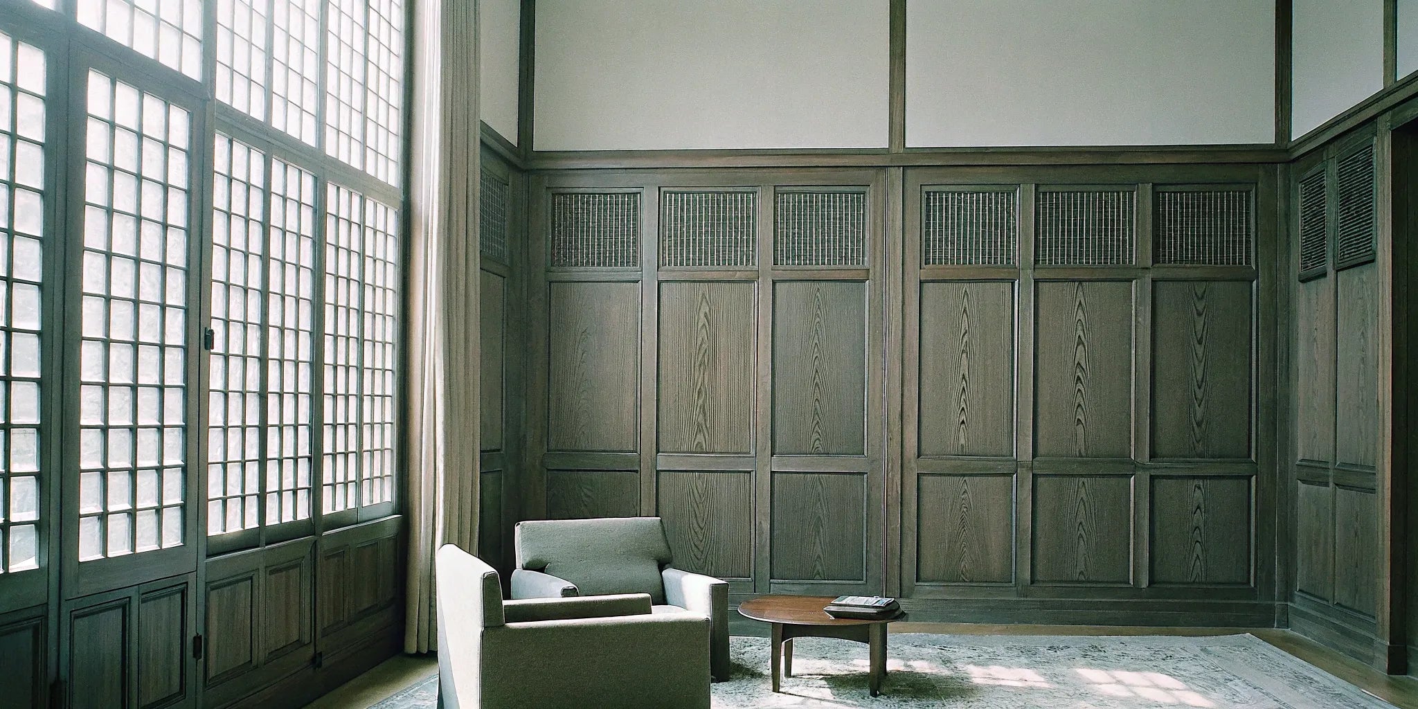 Large wood veneer acoustic panels on the wall of a modern, minimalist living room.