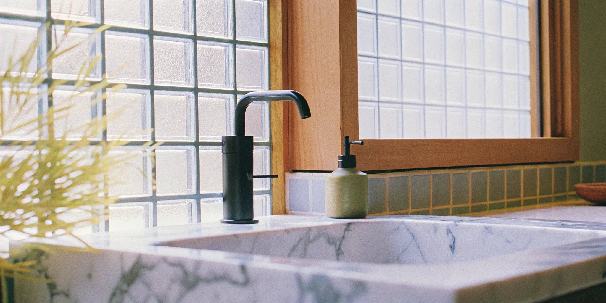 A sleek matte black faucet in a modern bathroom.