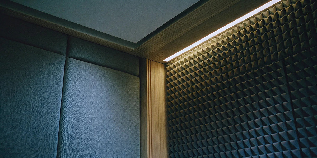 Acoustic panels vs. soundproofing on a wall, comparing sound absorption and sound blocking.