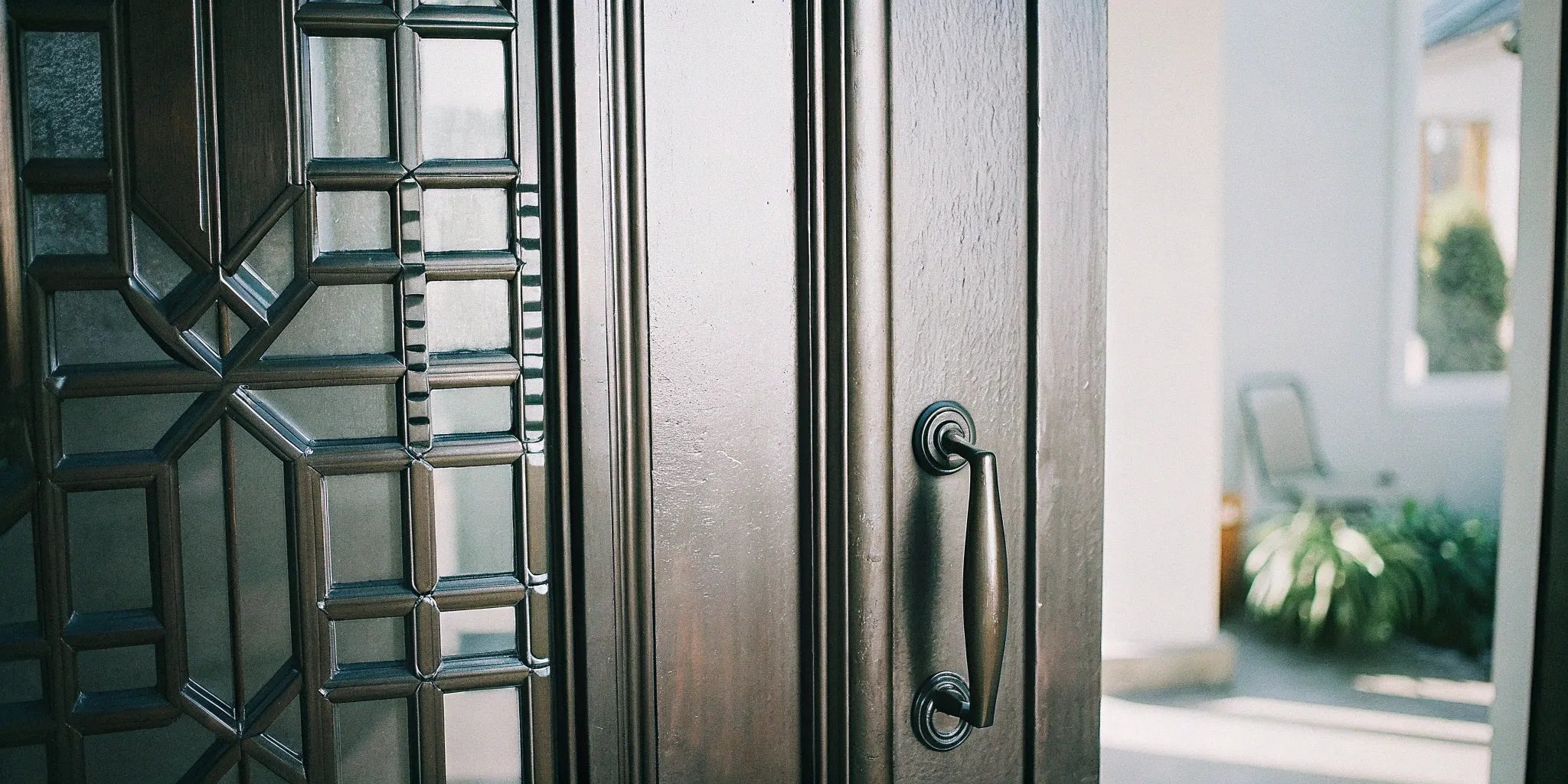 A custom steel door with a vertical glass panel and security lever handle.