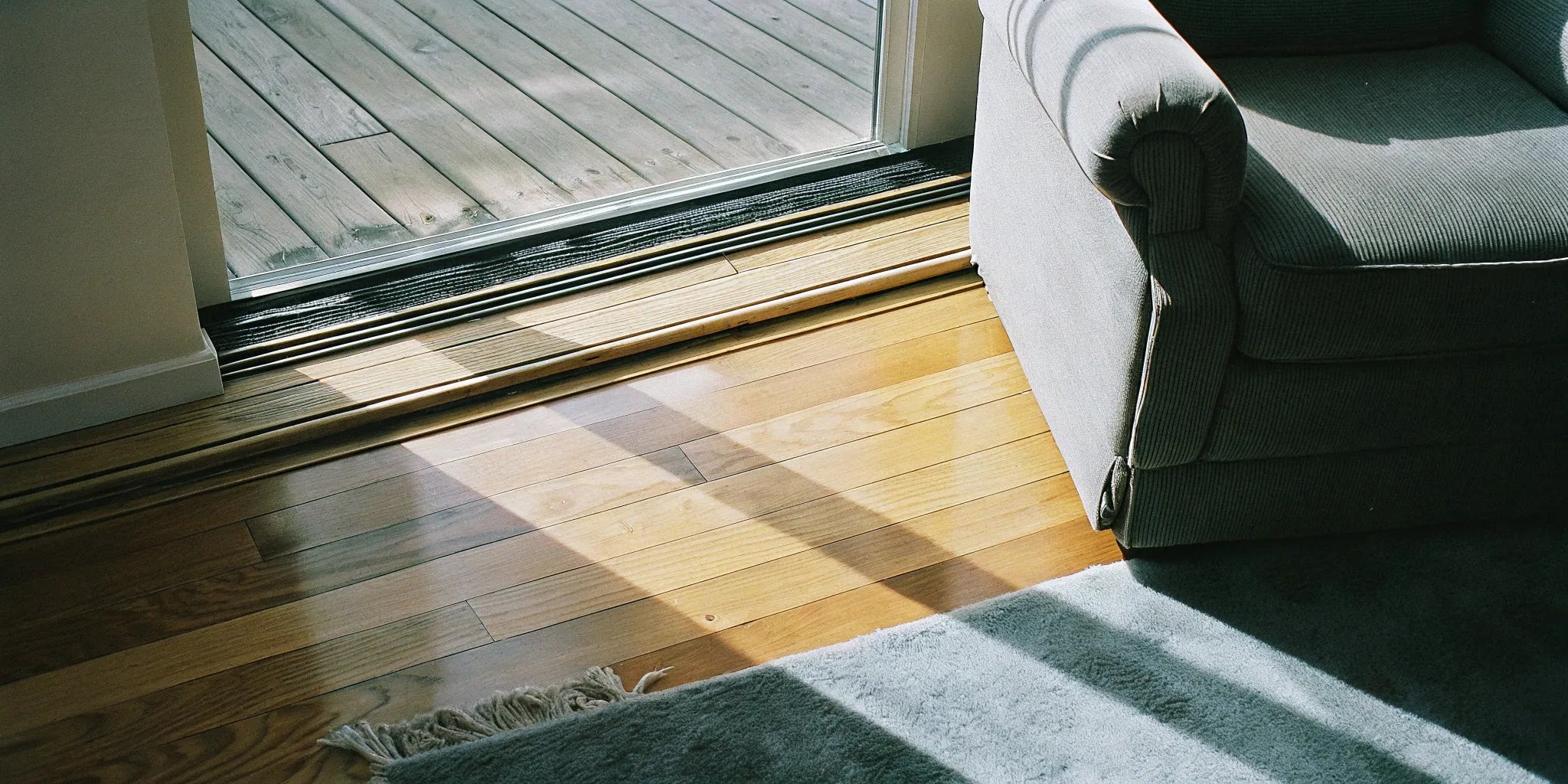 Hardwood flooring with natural wood grain near gray sofa.