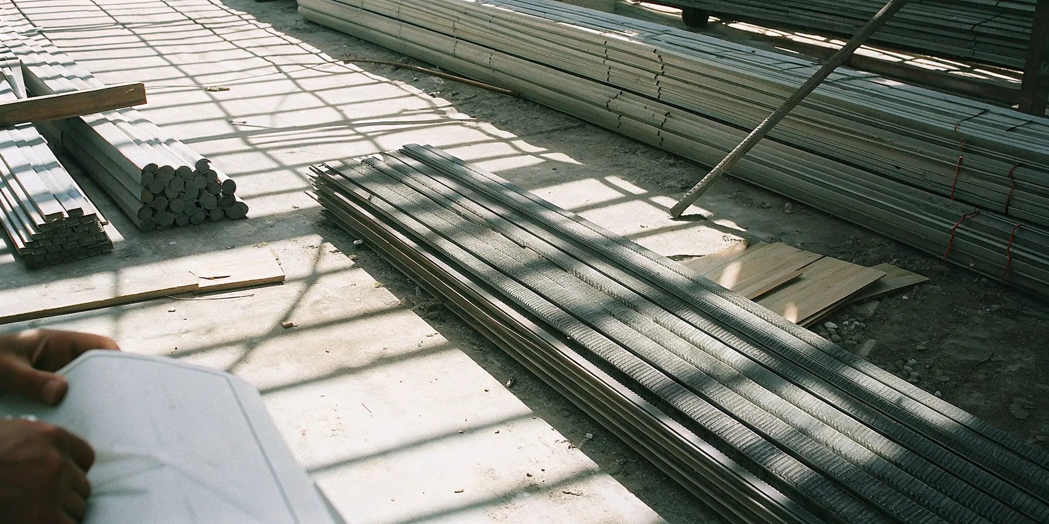 Steel construction materials stacked in a local supplier warehouse, ready for delivery.