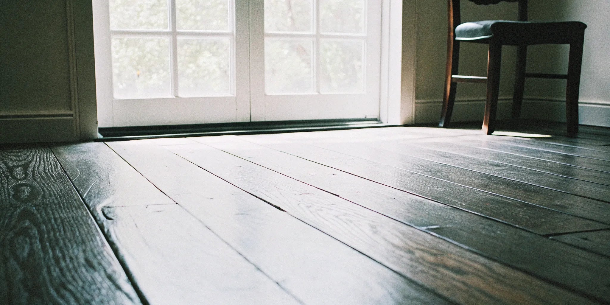 Engineered wide plank hardwood flooring near window.