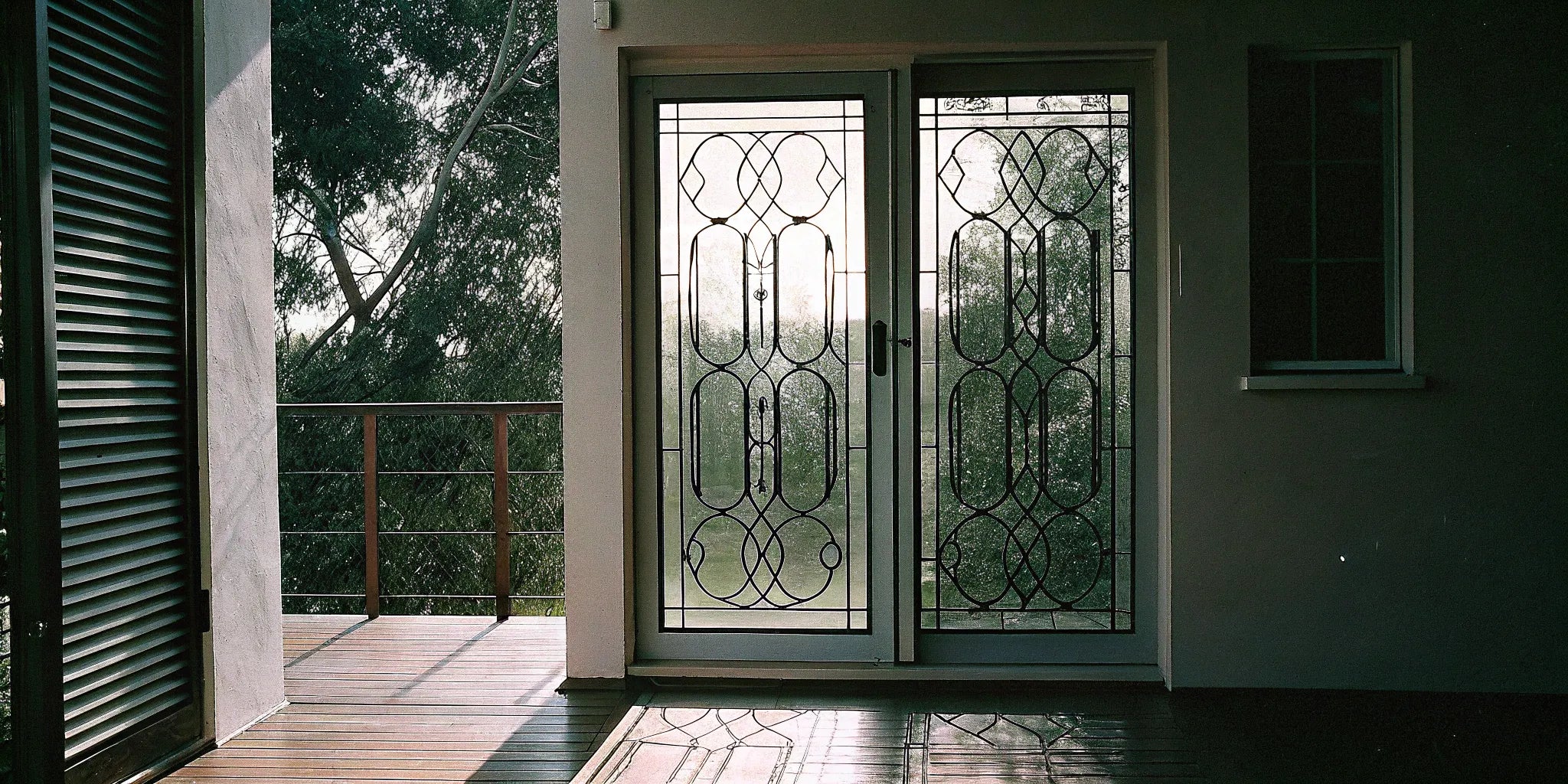 Modern metal exterior doors with decorative security glass panels.