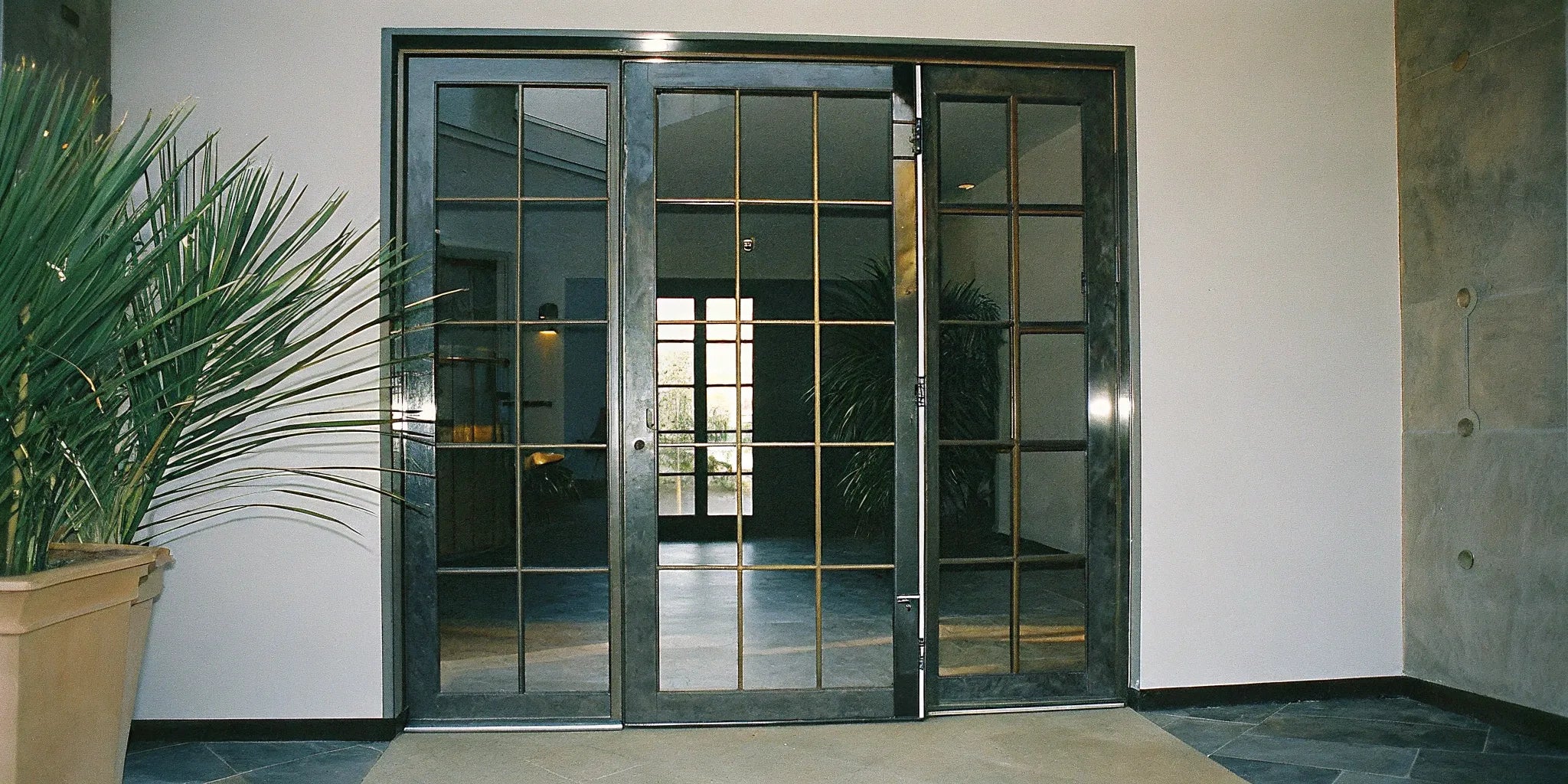 Modern steel front doors with a geometric glass panel design.