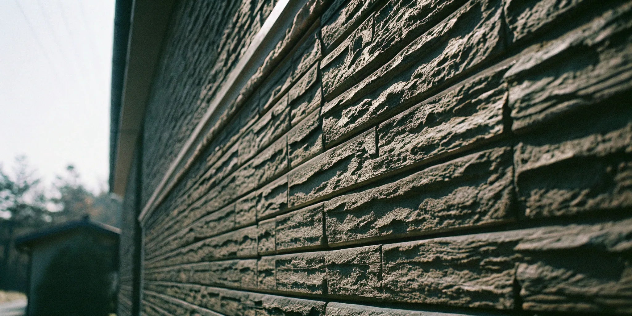 Textured stone wall panels on the exterior of a modern house.