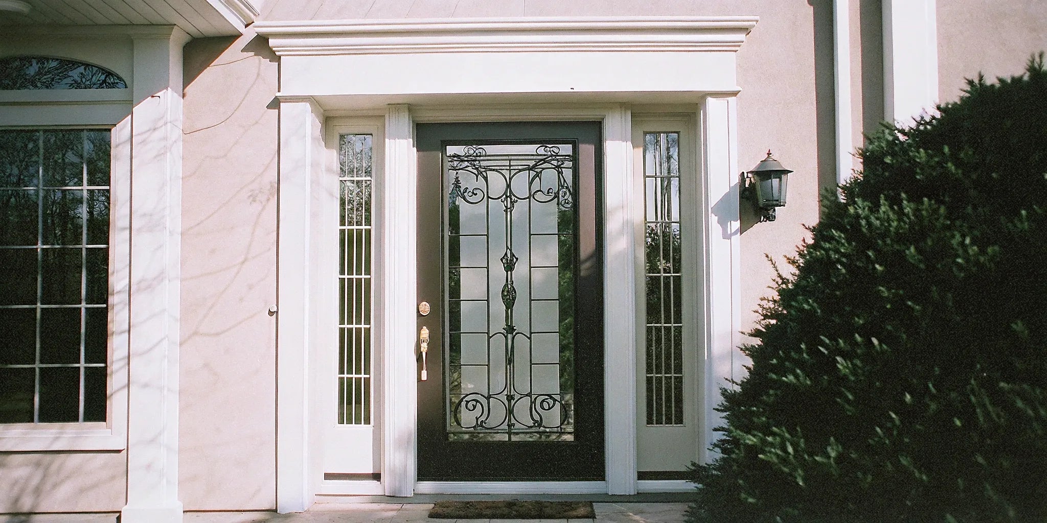 Front door with sidelights and decorative glass panels.