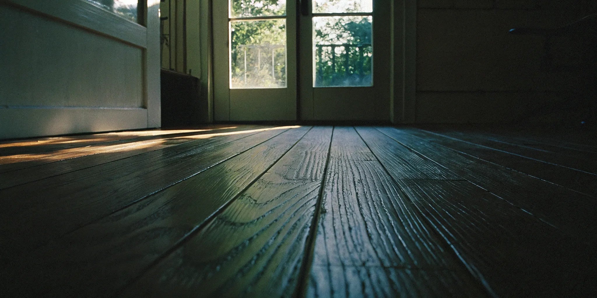 Wide plank flooring in a sunlit room, a key factor in the total project cost.