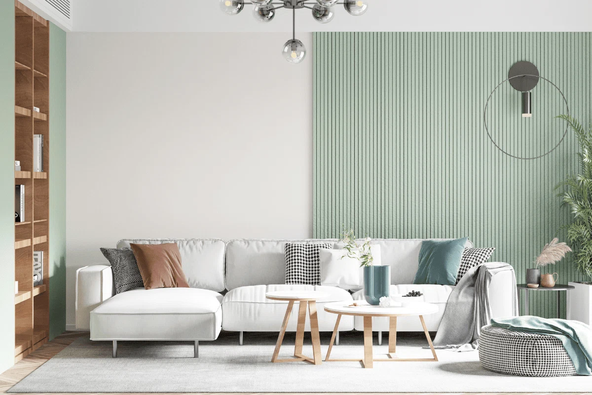 Modern living room with a white wall and mint green WPC fluted wall panel, white sofa, and six assorted cushions in brown, grey, white, checked black and white, and washed blue.